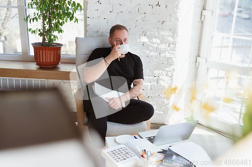 Image of Young man studying at home during online courses for teacher, medical service manager