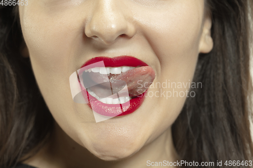 Image of Smiling girl opening her mouth with red lips and showing the long big giant tongue isolated on white background, crazy and attracted, close up