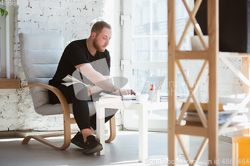 Image of Young man studying at home during online courses for programmer, bug-tester, consulter