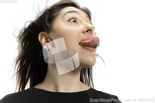 Image of Smiling girl opening her mouth and showing the long big giant tongue isolated on white background, crazy and attracted