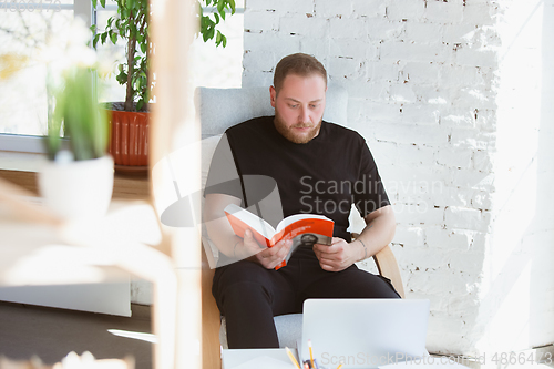 Image of Young man studying at home during online courses for programmer, bug-tester, consulter