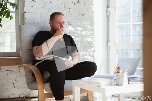 Image of Young man studying at home during online courses for teacher, medical service manager