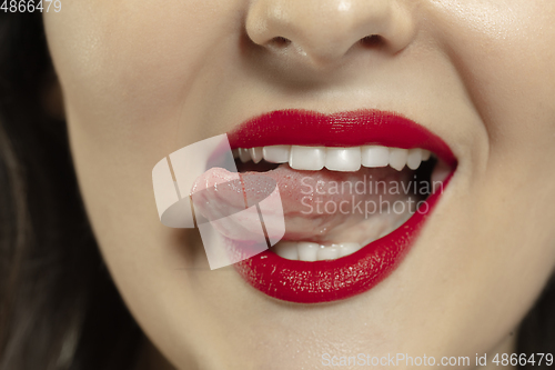 Image of Smiling girl opening her mouth with red lips and showing the long big giant tongue isolated on white background, crazy and attracted, close up