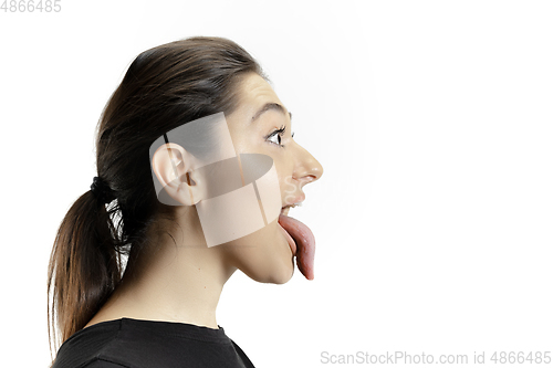 Image of Smiling girl opening her mouth and showing the long big giant tongue isolated on white background, crazy and attracted