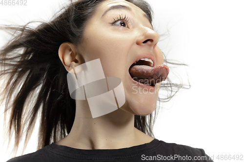 Image of Smiling girl opening her mouth and showing the long big giant tongue isolated on white background, crazy and attracted