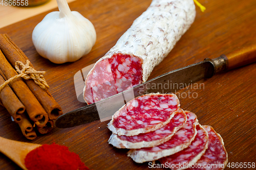 Image of traditional Italian salame cured sausage sliced on a wood board