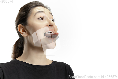 Image of Smiling girl opening her mouth and showing the long big giant tongue isolated on white background, crazy and attracted