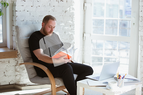 Image of Young man studying at home during online courses for programmer, bug-tester, consulter