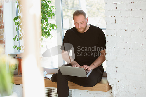 Image of Young man studying at home during online courses for designers, consultants, IT-managers