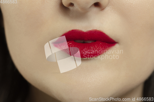 Image of Close-up female mouth with bright red gloss lips make-up. Cosmetology, dentistry and beauty care, emotions