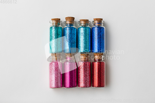 Image of set of glitters in bottles over white background