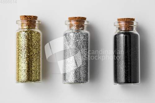 Image of set of glitters in bottles over white background