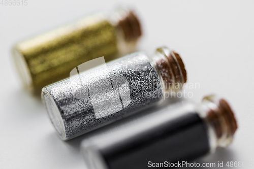 Image of set of glitters in bottles over white background