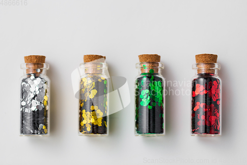 Image of set of glitters in bottles over white background