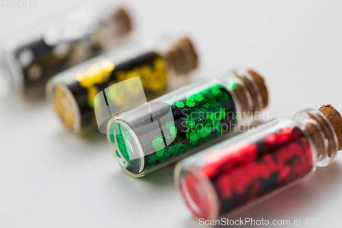 Image of set of glitters in bottles over white background