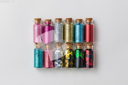Image of set of glitters in bottles over white background