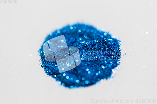 Image of blue glitters on white background