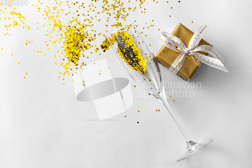 Image of champagne glass, gift and golden glitters