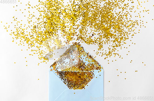 Image of golden glitters and envelope on white background