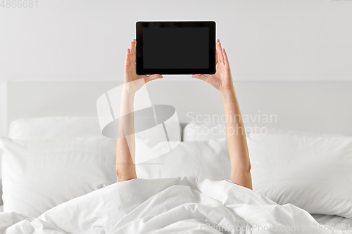 Image of hands of woman lying in bed with tablet computer