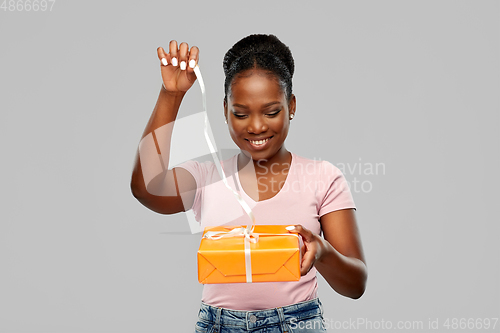 Image of happy african american woman with gift box