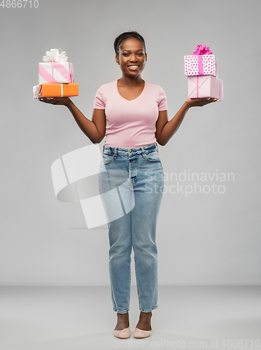 Image of happy african american woman with gift boxes