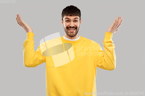 Image of smiling young man in yellow sweatshirt