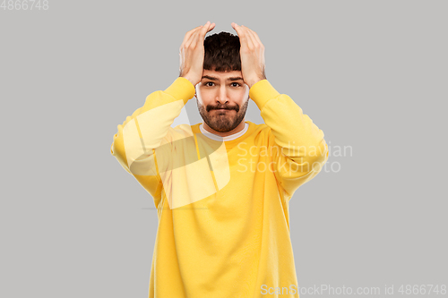 Image of desperate young man holding to head