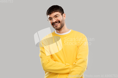 Image of smiling young man in glasses and yellow sweatshirt