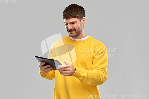 Image of displeased young man with tablet pc computer