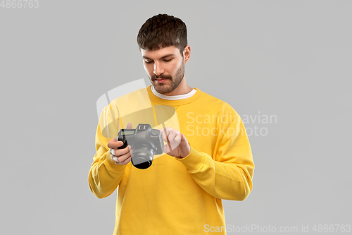 Image of young man with digital camera