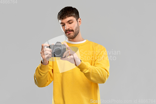 Image of young man with digital camera