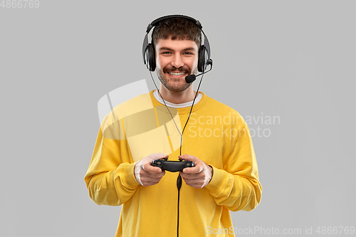 Image of man with headset and gamepad playing video game