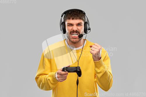 Image of man with headset and gamepad playing video game