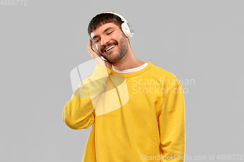 Image of happy young man in headphones listening to music