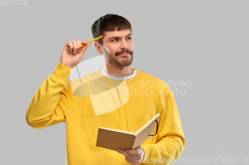 Image of thinking man with diary and pencil