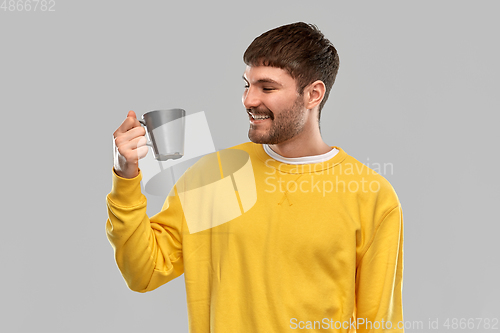 Image of happy smiling young man with coffee cup