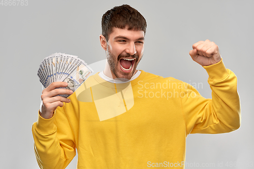 Image of happy young man with money celebrating success