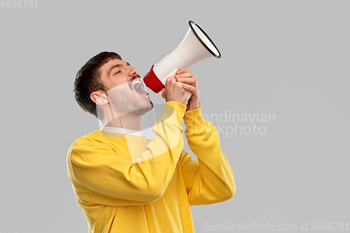 Image of man in yellow sweatshirt shouting to megaphone