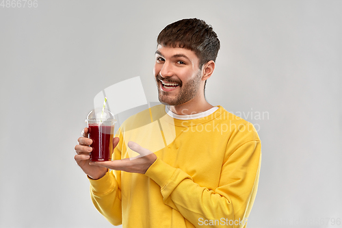 Image of happy man with tomato juice in takeaway cup