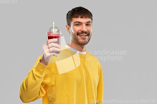 Image of happy man with tomato juice in takeaway cup