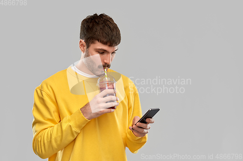 Image of man with smartphone and tomato juice