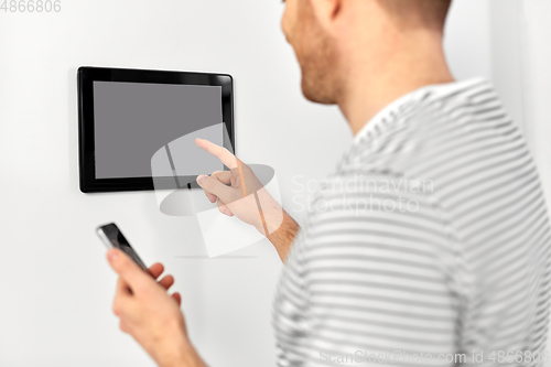 Image of man with smartphone and tablet pc at smart home