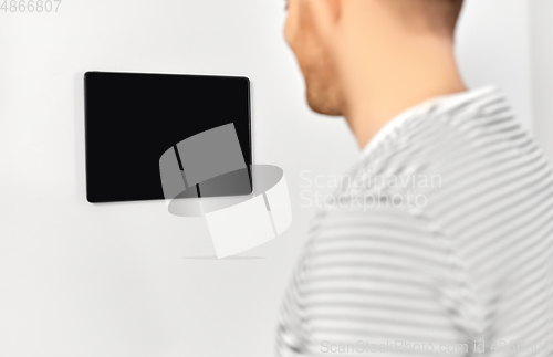 Image of happy man looking at tablet computer at smart home