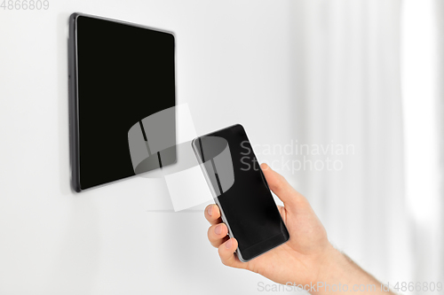 Image of man with smartphone and tablet pc at smart home