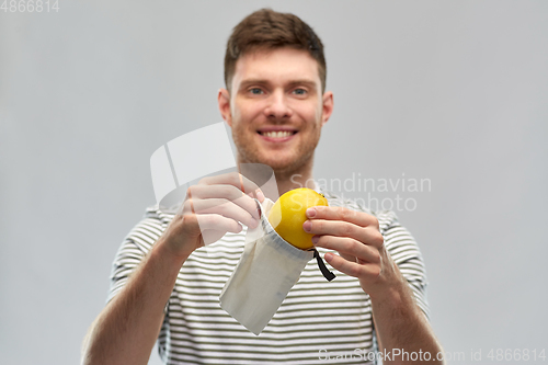 Image of smiling man with lemon in reusable canvas bag