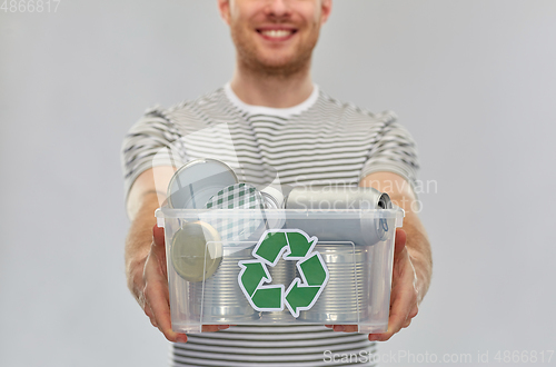 Image of smiling young man sorting metallic waste