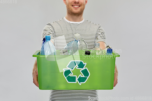 Image of smiling young man sorting plastic waste