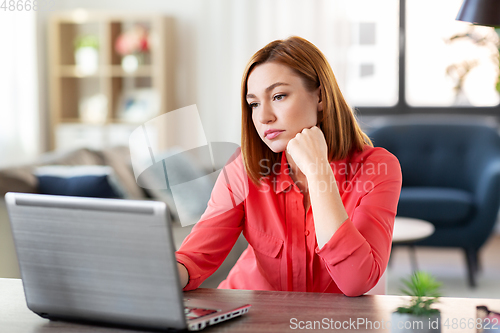 Image of bored woman with laptop working at home office