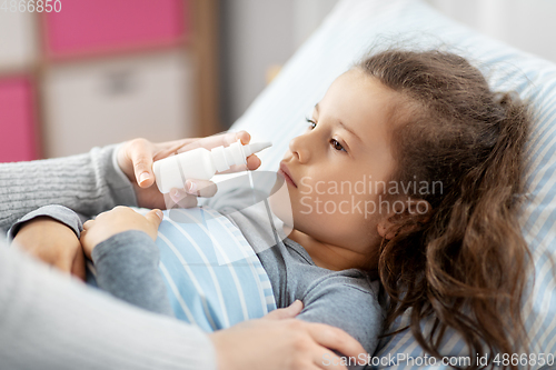 Image of mother with nasal spray treats sick daughter